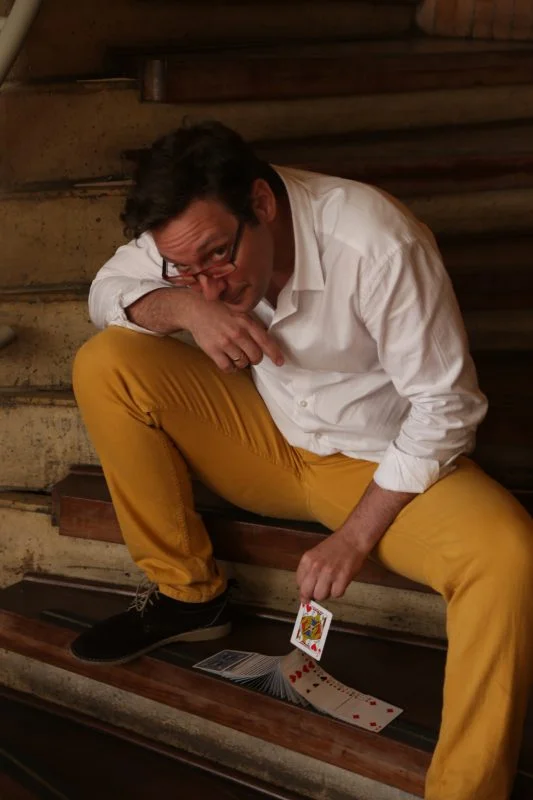 Otero en escaleras con cartas